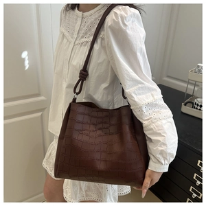 Borsa tote marrone con stampa coccodrillo indossata da modella per un look vintage chic