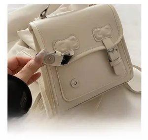 Détail du fermoir magnétique en argent et du cuir crème mat sur un sac à dos pour femmes