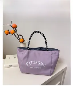 Detail of purple waterproof nylon tote bag with striped handles and side pockets