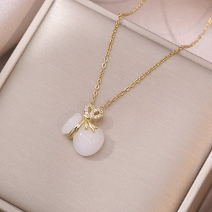 Vintage gold necklace featuring a sparkling money bag pendant with a white resin gem