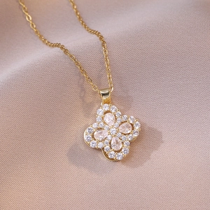 Collier trèfle doré élégant avec pétales en zircone cubique sur tissu rose