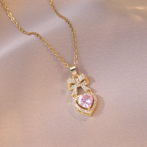 Elegante collana a fiocco dorata con pendente a cuore in zircone rosa e cristalli