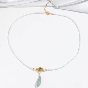 Detail of beaded necklace featuring enamel butterfly, pearls and green jade drop pendant