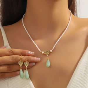 Elegant jewelry set with pearl necklace and butterfly earrings featuring green jade pendants