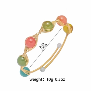 Detail of handmade wire-wrapped gold bracelet with colorful beads and dimension labels