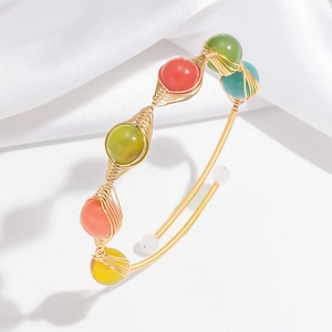 Detailed shot of handmade gold wire wrap bracelet with colorful strawberry crystal beads