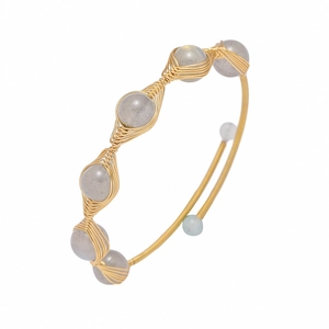 Detail of handcrafted gold wire-wrapped bangle featuring elegant grey natural gemstones
