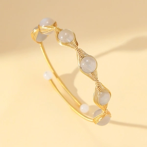 Detailed macro of gold wire-wrapped bracelet with natural stones and adjustable design