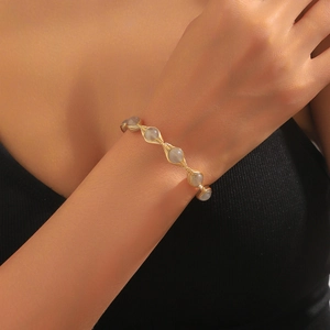 Detail of handmade gold wire-wrapped open cuff bracelet with grey translucent beads