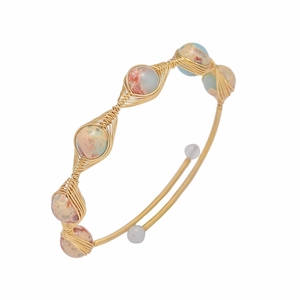 Detail of handmade gold wire-wrapped bangle featuring natural strawberry quartz beads