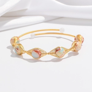 Detail of handcrafted gold wire open bangle with colorful strawberry quartz beads