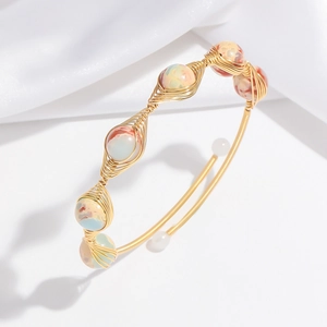 Detailed view of handmade gold wire-wrapped bangle with colorful stone beads