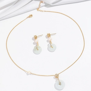 Elegant jewelry set featuring freshwater pearl and green jade clover pendant on gold chain