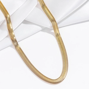 Détail d'un collier chaîne serpent dorée plate avec polissage miroir sur de la soie