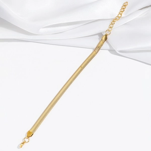 Détail d'un bracelet chaîne serpent doré minimaliste avec fermoir mousqueton robuste