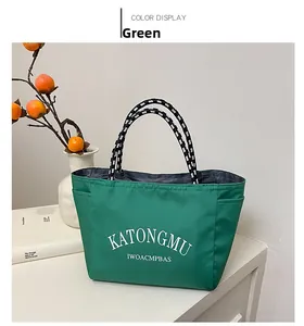 Detail of green nylon tote bag with polka dot handle on a minimalist white countertop