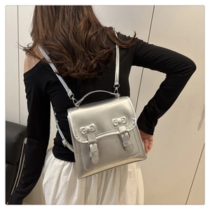Silver metallic square backpack featuring retro buckle straps and a top handle for style
