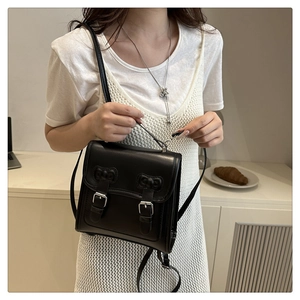 Detail of black vintage leather backpack with dual buckle closure and matte finish