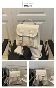 Détail du sac à dos blanc en cuir PU avec relief de nœud et boucles en métal argenté
