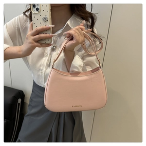 Detail der blassrosa Schultertasche mit FASHION-Schriftzug und Leder-Schultergurt
