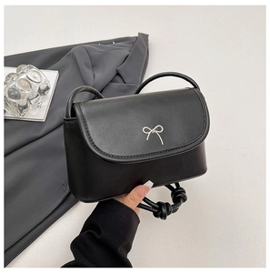 Détail du sac bandoulière noir avec nœud en argent et bandoulière en corde nouée