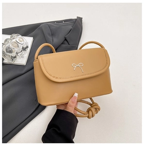 Détail du sac bandoulière en cuir kaki avec boucle nœud argentée et fine sangle d'épaule