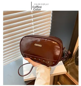 Detail of coffee brown vintage crossbody bag featuring polished finish and metal studs