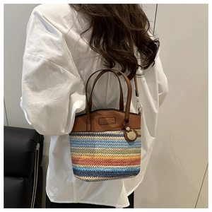 Detail of colorful rainbow straw woven crossbody bag with brown leather handles