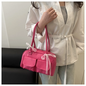 Detail of rose red Y2K shoulder bag with white lace bows and double front pockets