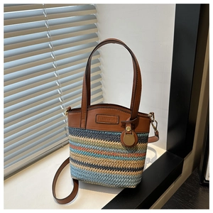 Detailed close-up of rainbow straw woven crossbody bag with brown faux leather trim and strap