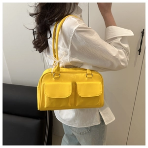 Detail of bright yellow shoulder bag with double pockets and white lace bow decoration
