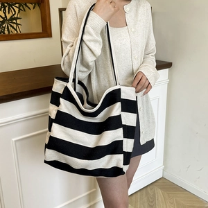 Large capacity black and white striped canvas tote bag shown with model in casual setting