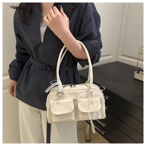 Detail of creamy white handbag featuring lace bow and dual front flap pockets