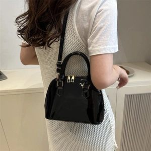 Glossy black patent leather shell bag with gold hardware and adjustable strap for women