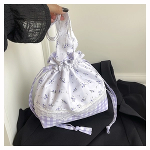 Detail of floral and checkered drawstring bag with white lace trim and purple accents