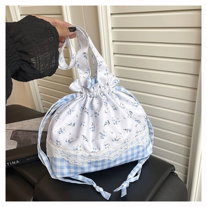 Detailed shot of drawstring canvas bucket bag with blue floral print and lace trim