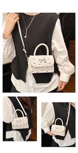 Détail du mini sac blanc avec imprimés papillons et décoration de nœud argenté