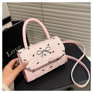 Dettaglio mini borsa rosa con motivi a fiocco nero e fibbia a fiocco in metallo argento