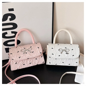 Vue détaillée des mini sacs à nœuds rose et blanc avec texture à pois et nœud métal