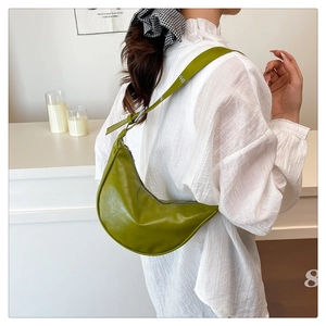 Detail of green crescent moon bag with silver zipper and leather texture