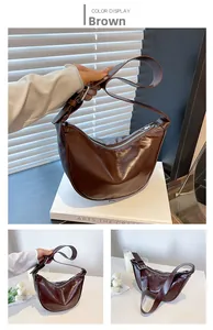 Detailed view of brown PU leather dumpling bag with silver eyelets and wide strap