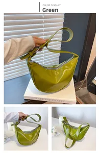 Close-up of a green hobo bag with glossy finish and silver eyelet strap detail