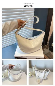 Detail of white crescent crossbody bag with glossy wax finish and adjustable wide strap