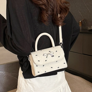 Piccola borsa a tracolla bianca con motivi a fiocco nero e fibbia a fiocco argentata