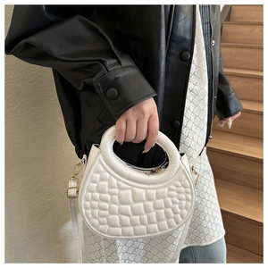 Close-up of a white semicircular PU leather crossbody bag with quilted texture and gold hardware