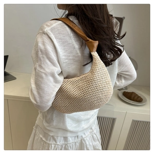 Detail der beige geflochtenen Tragetasche mit braunem Lederriemen und Knotendesign