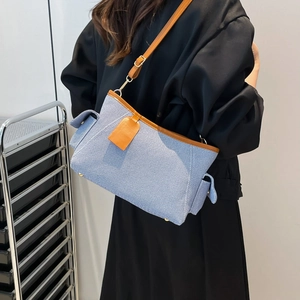 Light blue textured fabric shoulder bag with brown leather trim and golden hardware