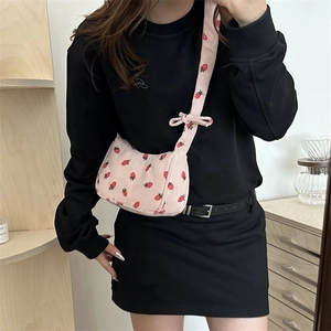 Pink corduroy shoulder bag with strawberry print and bow straps for a cute casual look