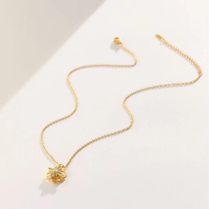 Collana con ciondolo a fiore rotante dorato e zirconi incastonati su catena sottile