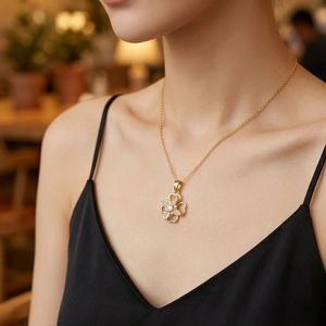 Collana a quadrifoglio rotante in oro con micro-zirconi indossata da una modella
